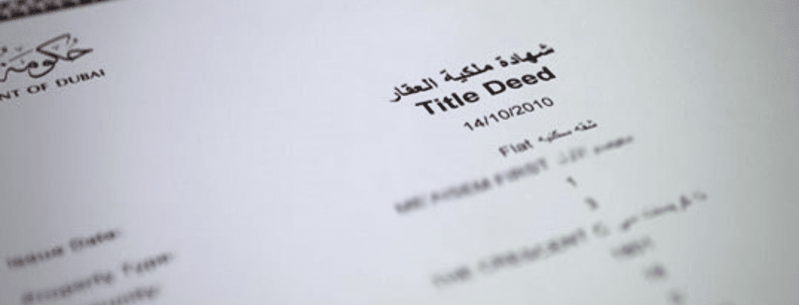Close-up of a Dubai title deed document dated 14/10/2010, featuring Arabic and English text, with details about a flat.