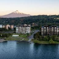 Aerial view of lakeside condos with a snow-capped mountain in the background.