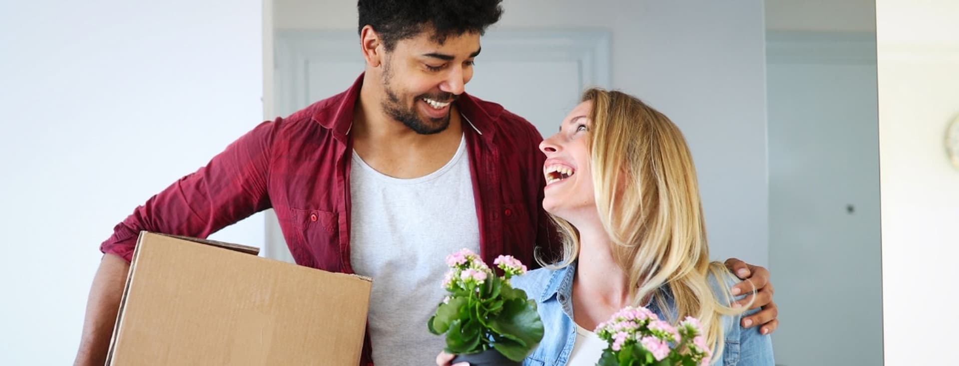 First time home buyers move boxes and plants into their new property