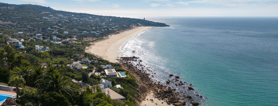 Panoramablick auf die Costa de la Luz mit der Stadt und ihrer Natur und dem Meer rechts.