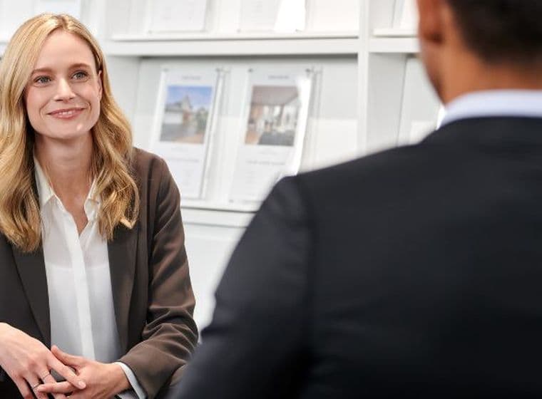 Real estate agent discussing with a client in an office setting