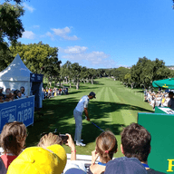 Campionat de golf patrocinat per Rolex. Un jugador està competint i la gent l'està mirant.