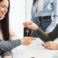 A real estate agent screens two potential tenants on behalf of the landlord.