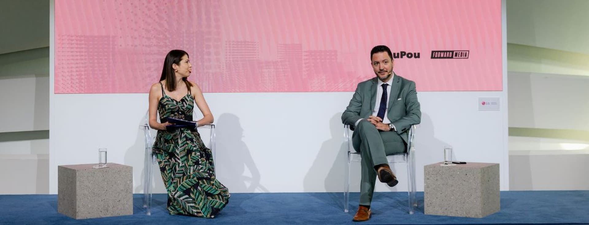 Panel discussion at White Paper The Event featuring a moderator and guest speaker on stage during a live business conversation
