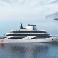 Un yacht de luxe blanc sur une mer bleue et calme, avec en arrière-plan la côte verdoyante et montagneuse.