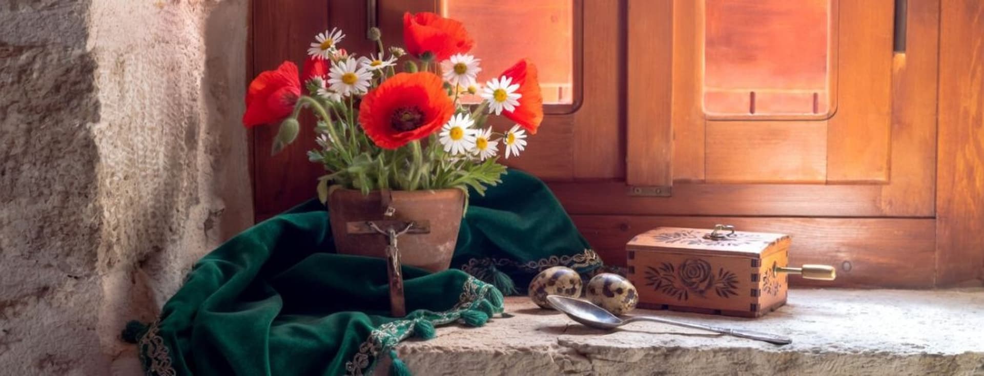 Rustic windowsill still life with red poppies, daisies, green cloth, and wooden music box in warm sunlight.