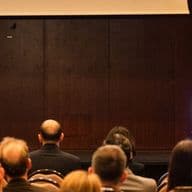 Conference speaker presenting to an audience at a real estate industry event.