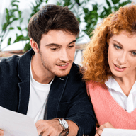 couple reading documents sitting at a desk