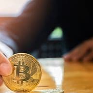 Man holds an imitation bitcoin cryptocurrency for buying real estate in Dubai