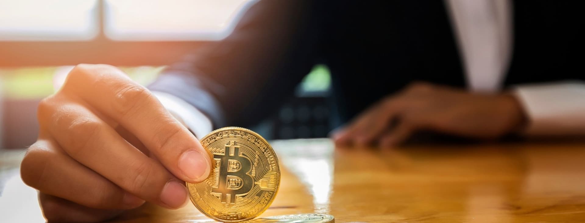 Ein Mann hält eine Nachbildung der Kryptowährung Bitcoin, um Immobilien in Dubai zu kaufen.