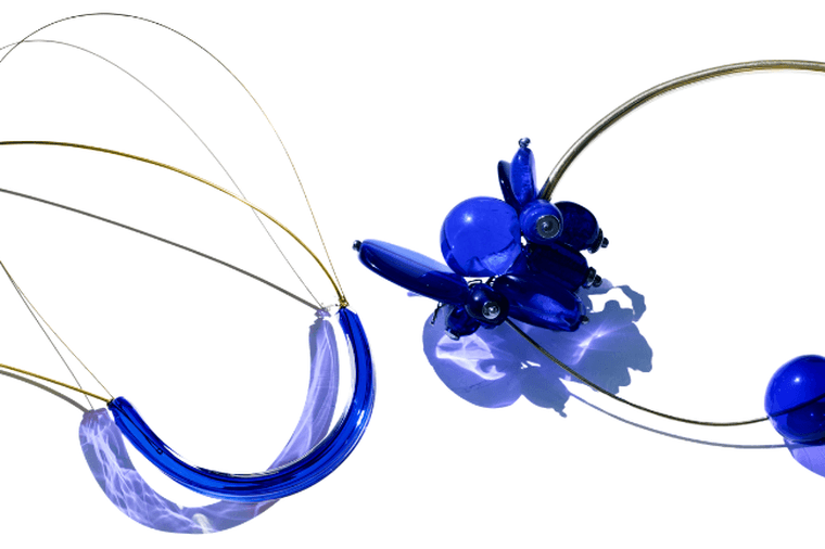 Two wire-wrapped blue bead necklaces; left features a shell pendant, right has chunky cobalt glass beads.