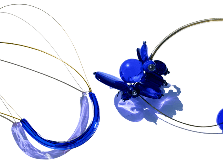 Two wire-wrapped blue bead necklaces; left features a shell pendant, right has chunky cobalt glass beads.
