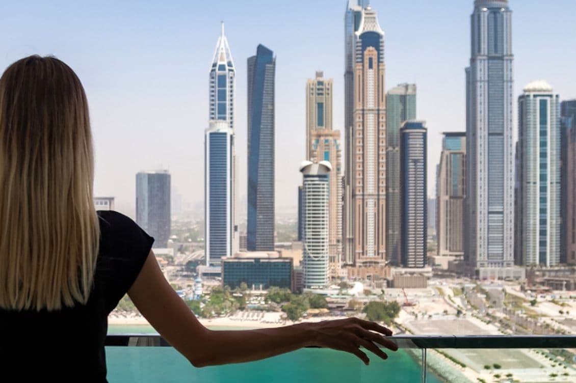 Woman stands on the balcony of a holiday home in Dubai