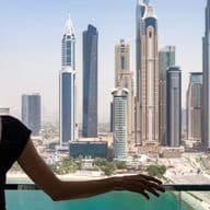 Woman stands on the balcony of a holiday home in Dubai