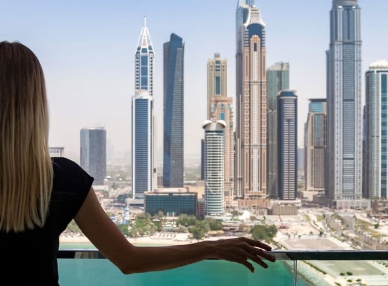 Woman stands on the balcony of a holiday home in Dubai