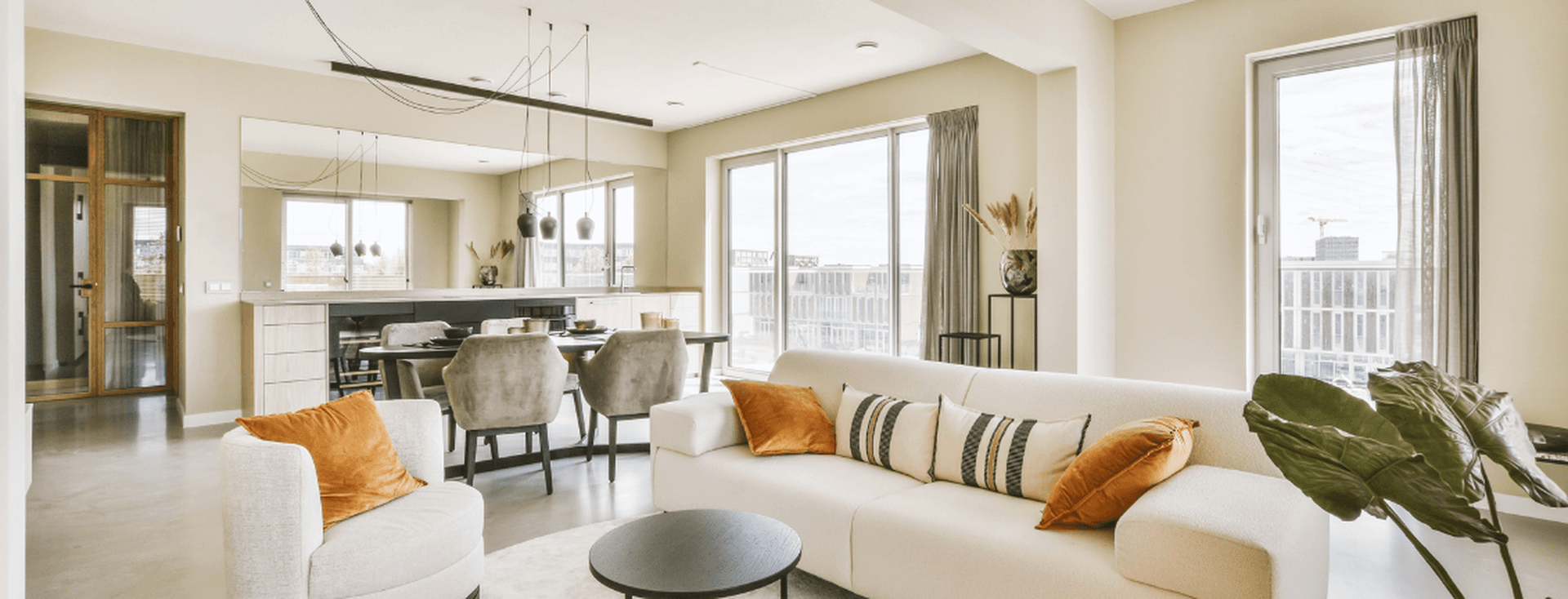 A bright and spacious open-plan apartment with modern furnishings, illustrating key factors like layout, natural light, and design when buying an apartment.