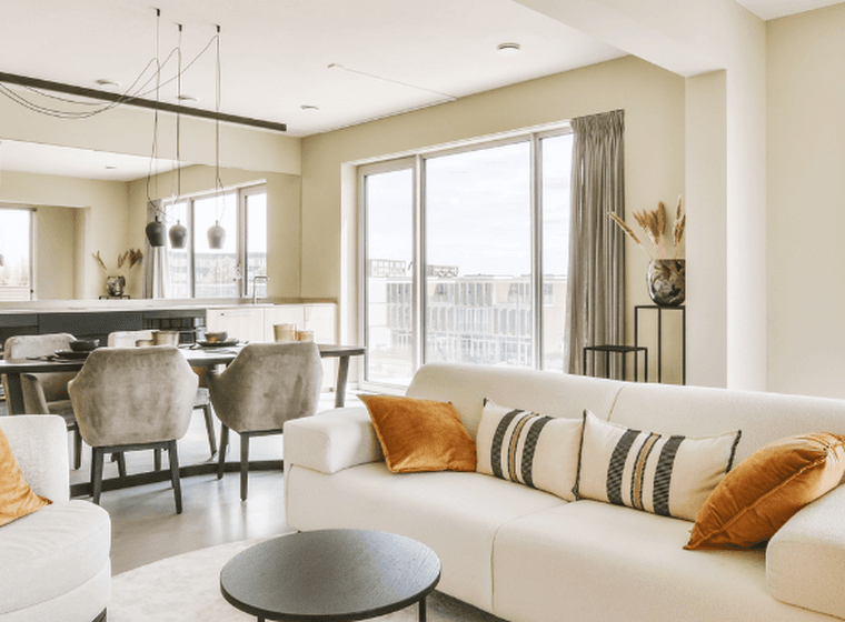 A bright and spacious open-plan apartment with modern furnishings, illustrating key factors like layout, natural light, and design when buying an apartment.