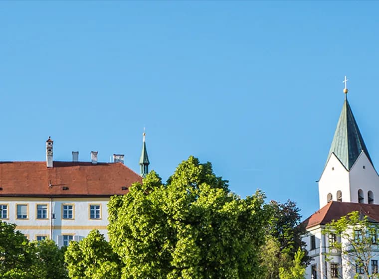 Towers of Freising Cathedral overlooking green landscapes – living in Freising with nature and city flair
