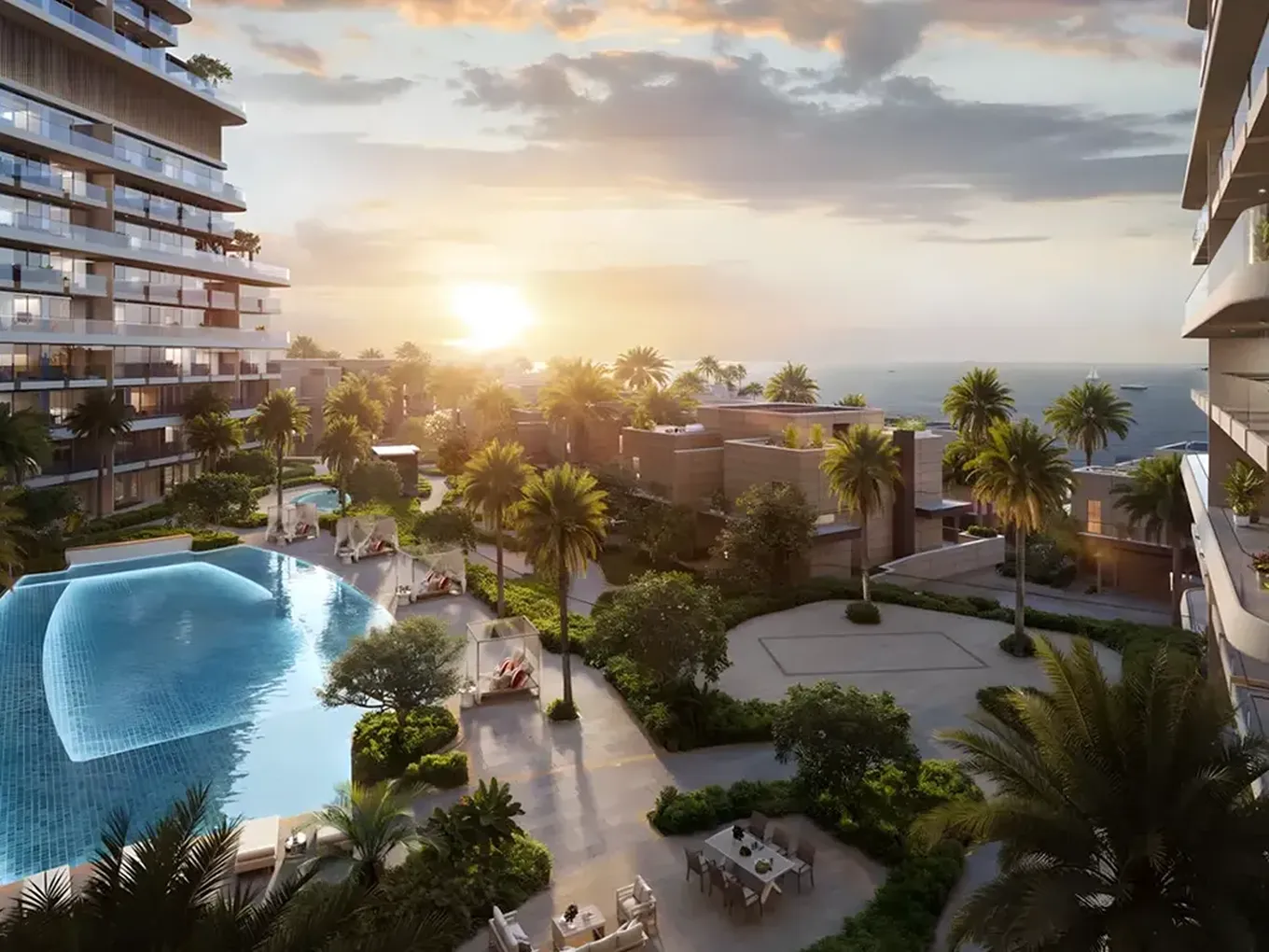 Sunset view of a modern seaside residential complex with a curved infinity pool, palm trees, balconies and ocean in the distance.