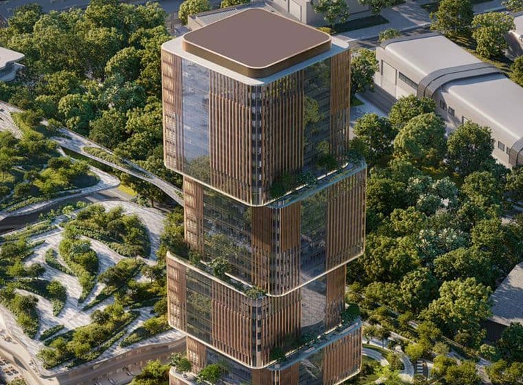 Aerial view of the 31 Above tower featuring its stacked glass architecture, warm vertical fins, and lush landscaped surroundings.