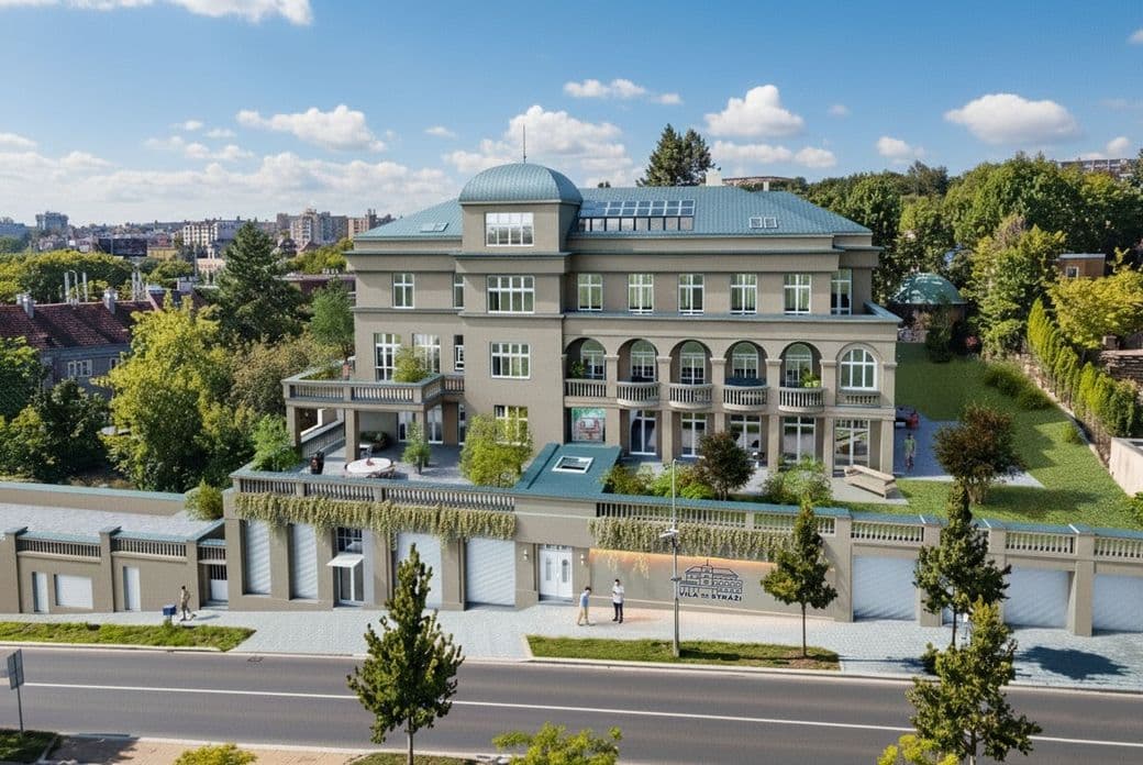 Aerial view of a villa with terraces, arched balconies, and a green roof, set amid mature greenery in a city neighborhood.