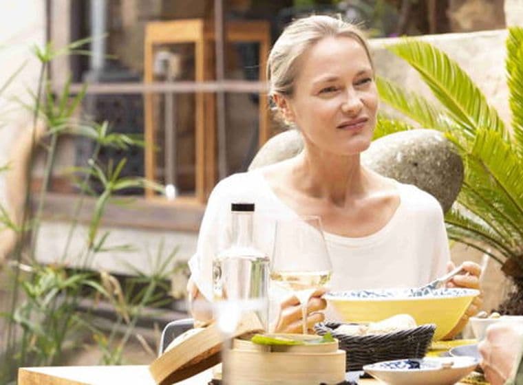 A women and a man outdoors enjoying a meal.