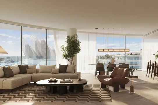 Spacious, modern living room with beige sofa, brown armchair, large windows offering a city view, and elegant decor in neutral tones.