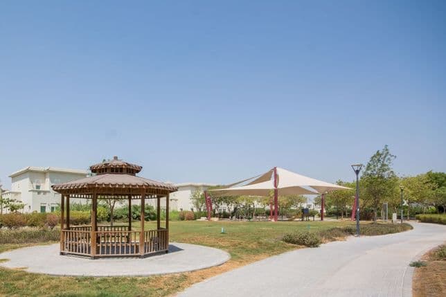 Beautiful park in Al Furjan with a pergola, well-maintained lawns, and benches
