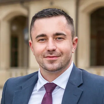 Portrait of Lukáš Cestr, a residential rentals specialist, wearing a dark suit and burgundy tie.