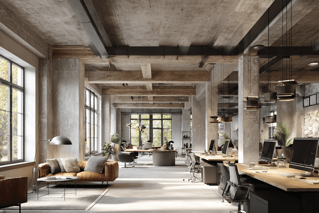 Modern open-plan office with industrial elements, featuring large windows, ceiling lights, multiple workstations, and a cozy seating area.