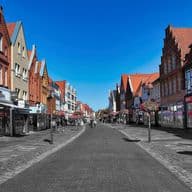 Blick in eine Fußgängerzone mit Wohn- und Geschäftshäusern