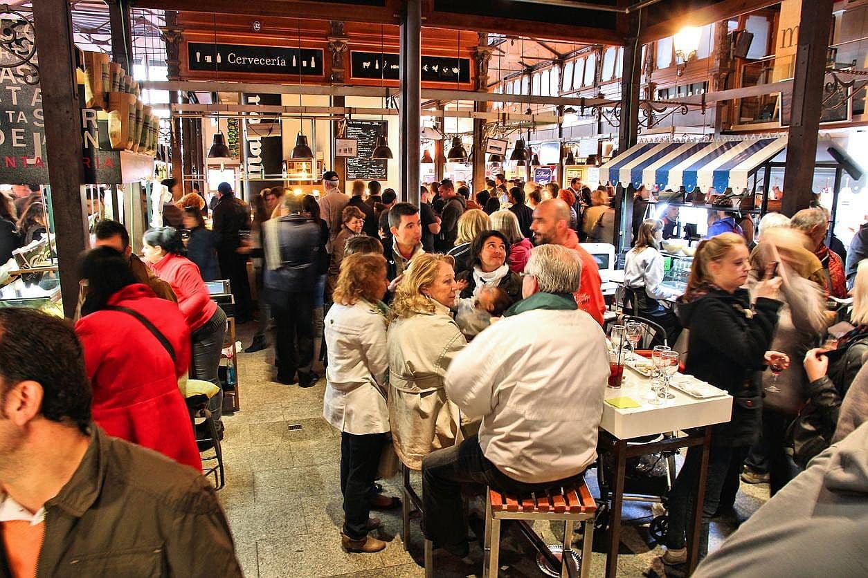 Personas reunidas dentro de un mercado en Torrevieja, algunos están comiendo, otros paseando.