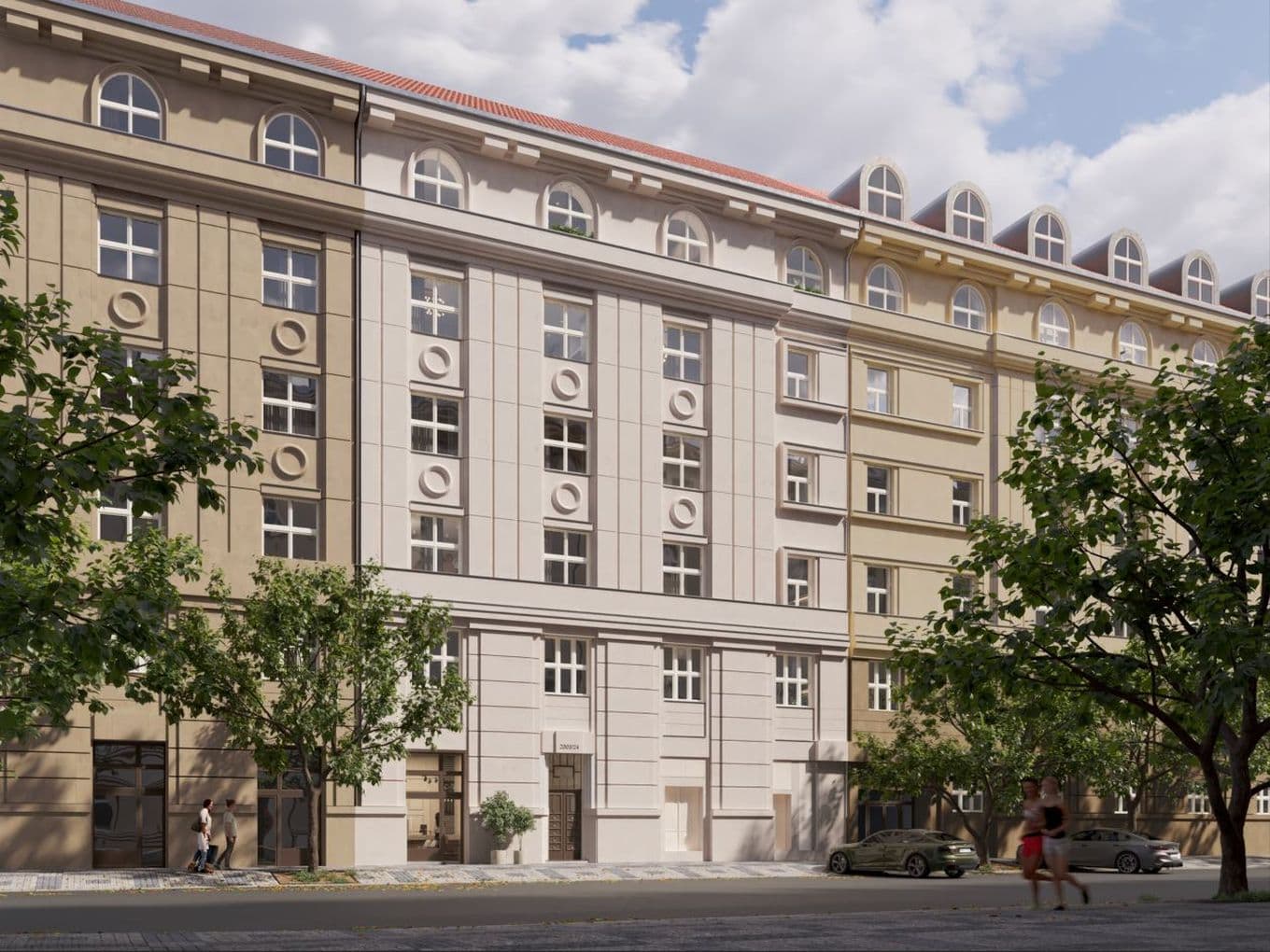 Street view of a multi-storey historic urban building with a light and beige façade decorated with circular reliefs and arched top-floor windows. Trees, pedestrians, and parked cars appear in the foreground.