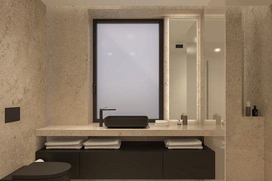 Minimalist beige stone bathroom with frosted window, black floating vanity and vessel sink, wall-mounted toilet, illuminated mirror.