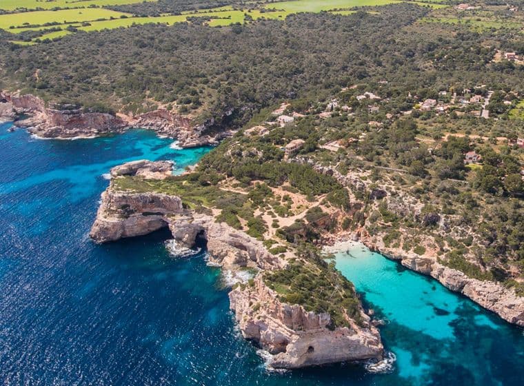 Aerial view of a rocky coastline with clear turquoise water