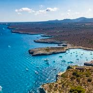 Luftaufnahme der Küstenlinie mit Booten und Bergen.