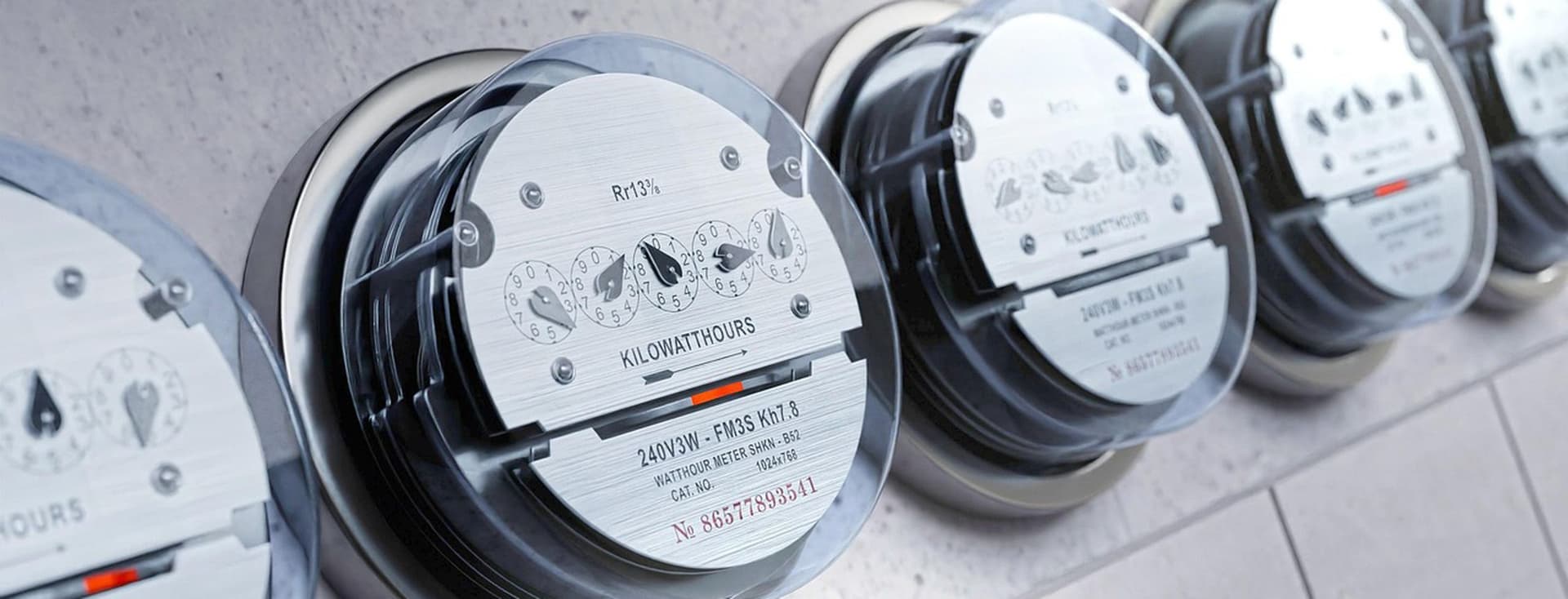 Several electricity meters mounted in a row on the wall
