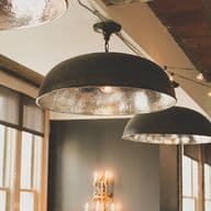 Blick in ein rustikales Restaurant mit Lampen im Industrie-Style