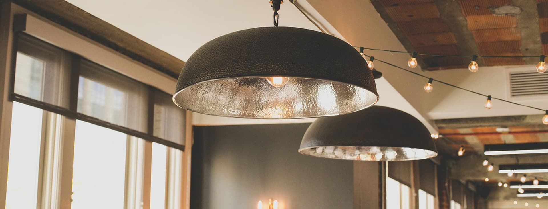 View into a rustic restaurant with industrial-style lamps