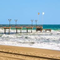 The pier next to marbella club hotel in Marbella by the beach with a lot of waves and a windy day