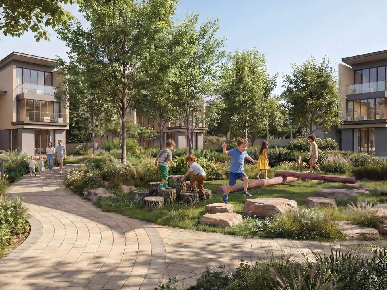 Children play on logs and rocks in a lush park surrounded by modern homes, while a family walks along a winding path under clear skies.
