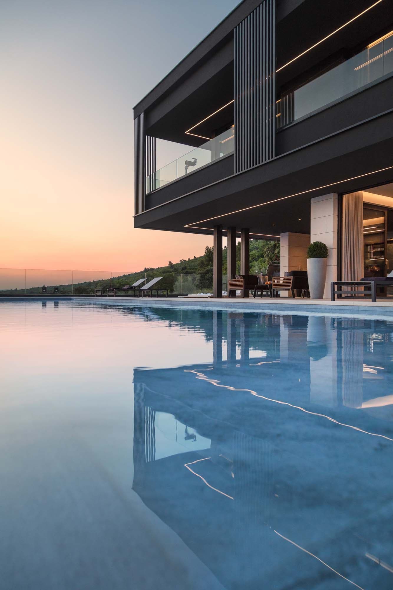Spiegelglatt reflektiert der beheizte Infinitypool das Licht der Abenddämmerung und verlängert den Blick auf die Adria. Ein Whirlpool rundet den Fünf-Sterne-Komfort im Außenbereich ab.
