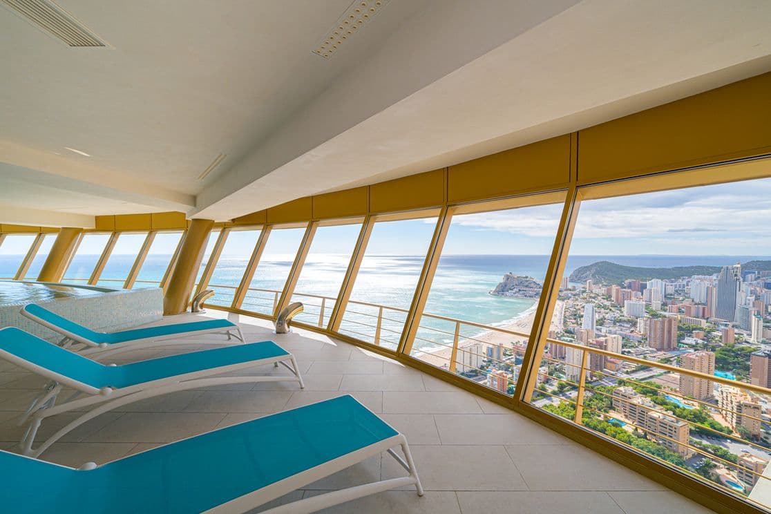 Luxuriöses Spa im 46. Stock des Intempo-Turms, mit Blick auf die Stadt, den Strand und das Meer. Drei Liegen sind zu sehen.