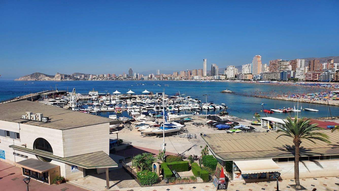 The marina of Benidorm from the castle with its boats and skyscrapers and sea on the horizon