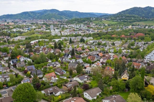 Luftaufnahme von Freiburg St. Georgen mit Wohnhäusern, viel Grün und Blick auf die Schwarzwaldhügel