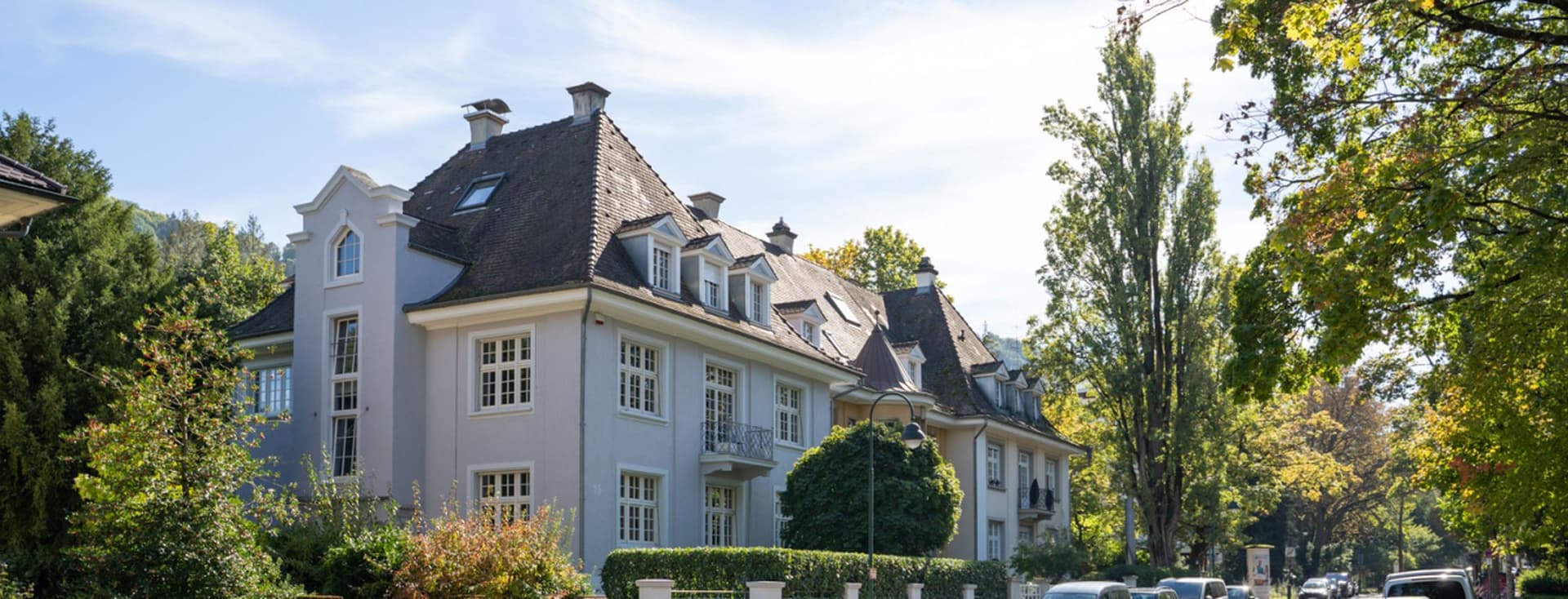Repräsentative Häuser mit Vorgärten und Baumallee in Freiburg-Herdern an einem sonnigen Tag