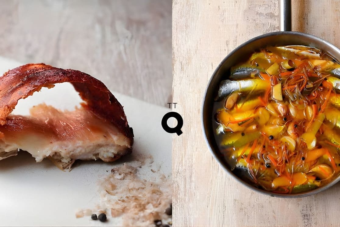 A cooked fish with crispy skin on the left and a pan of colorful sardine stew with vegetables on the right, placed on a wooden surface.