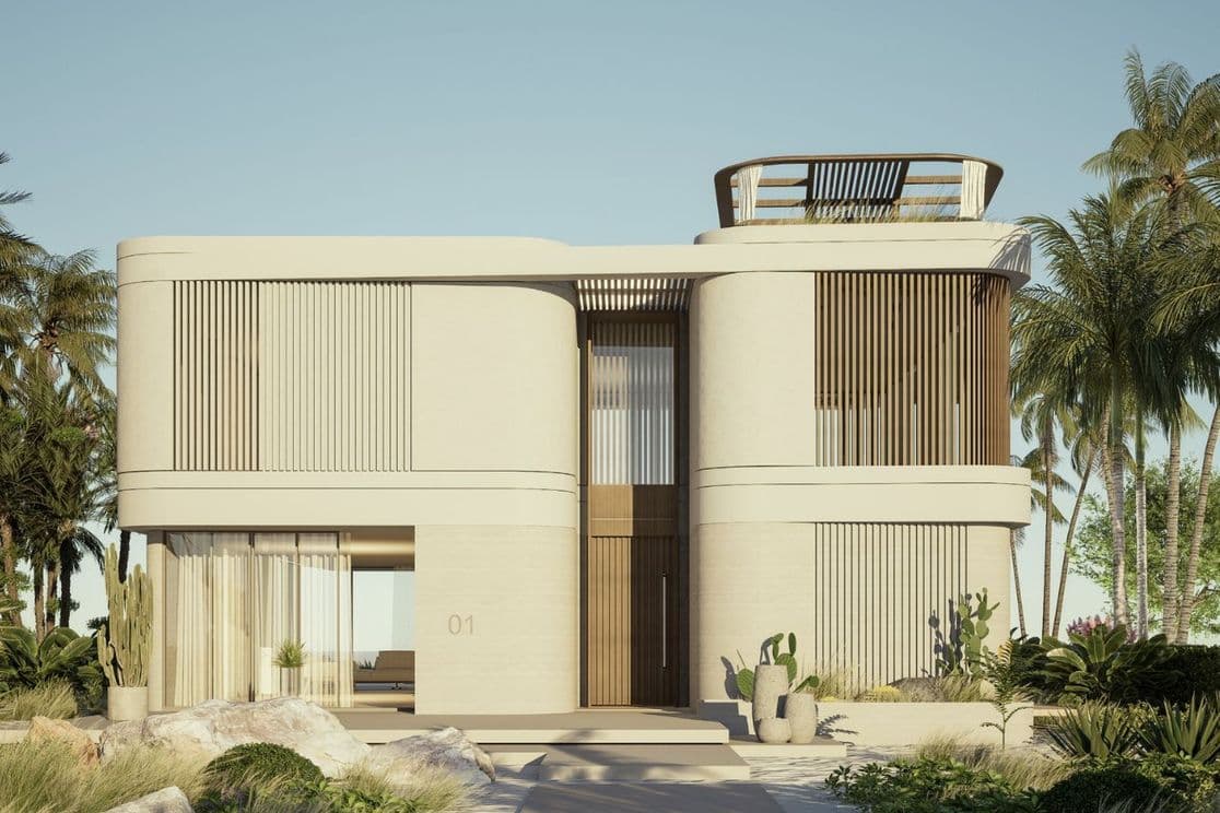 Front view of a contemporary beachfront villa with curved walls, vertical wooden slats, and tropical landscaping.