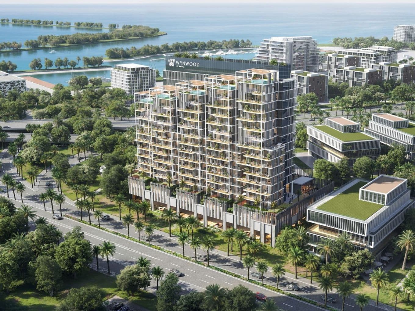 Luftaufnahme des Wohnhochhauses Wynwood, umgeben von Bürogebäuden mit begrünten Dächern und der Uferpromenade der Dubai Islands.