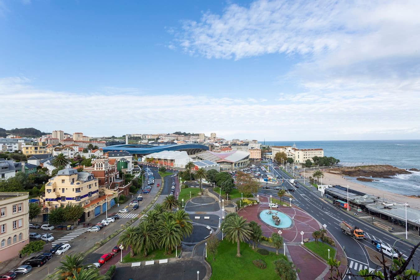 Klarer Blick von einer Wohnung am Plaza de Portugal, von wo aus man die Gegend von Riazor sehen kann, mit dem Strand, dem Park, dem Fußballstadion der Stadt und den charakteristischen Palmen der Gegend.